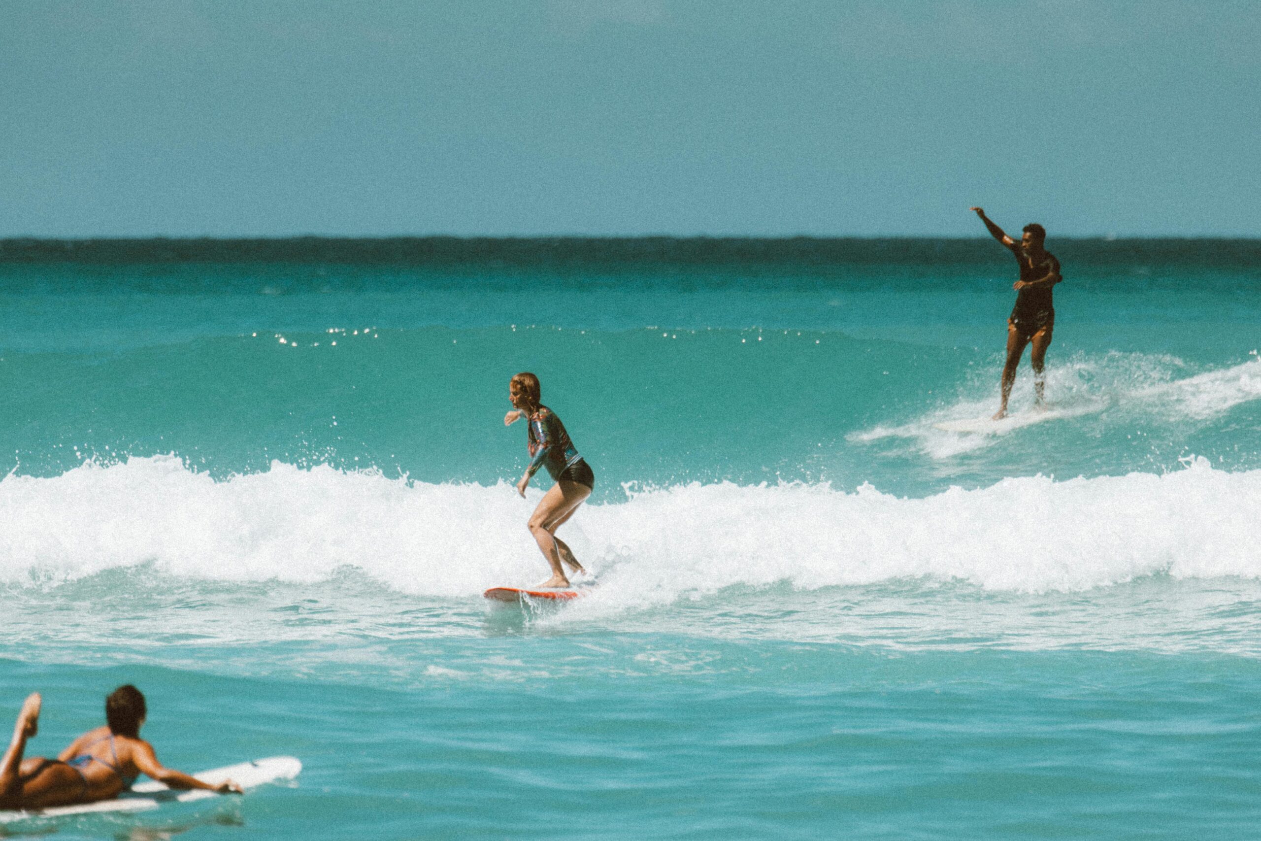Home Surfers ride waves in Hawaii, showcasing surf culture and crystal-clear waters.